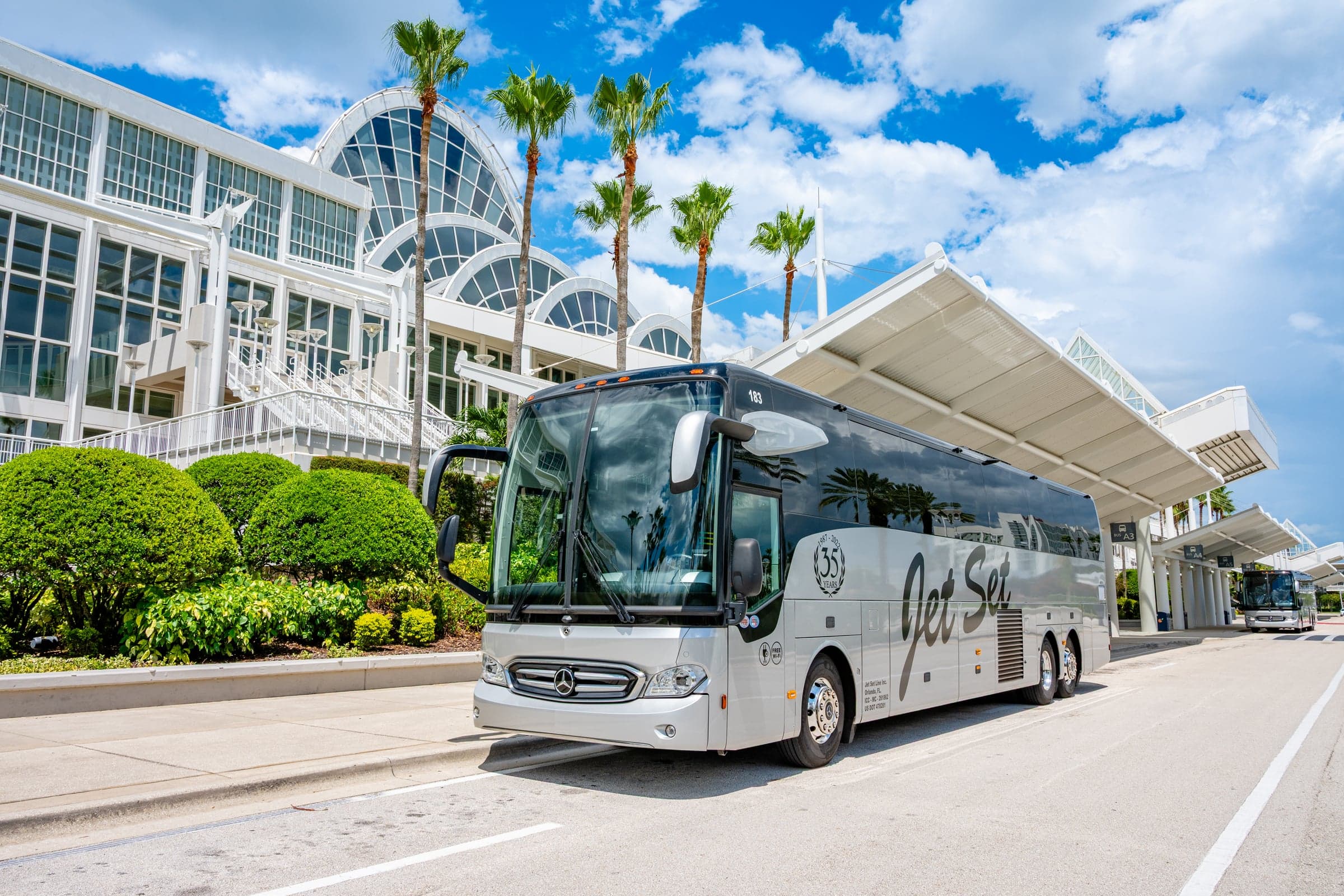 A Jet Set Line Mercedes-Benz Tourrider motorcoach at a convention center drop-off