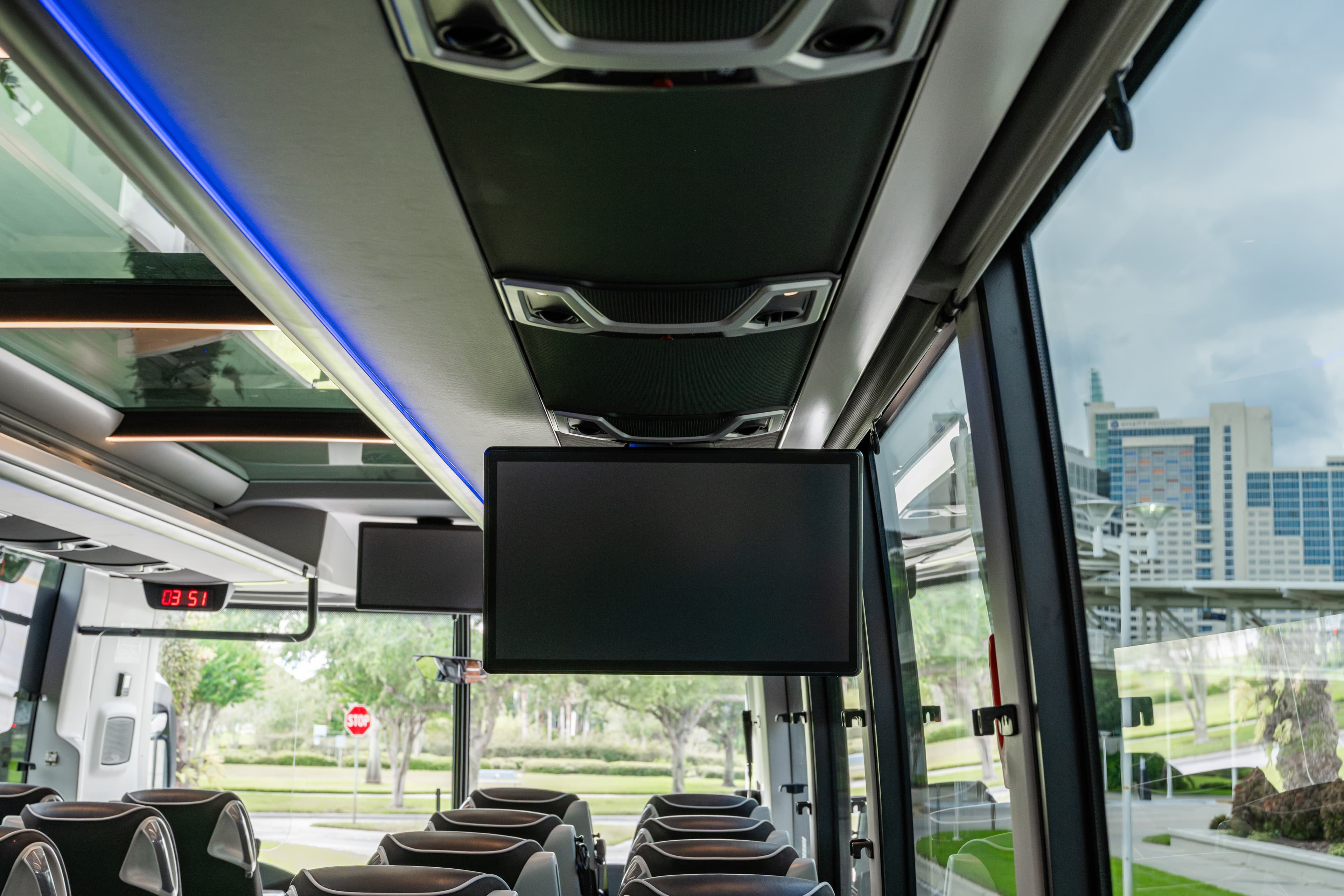 Interior de um ônibus da Jet Set Line: bancos de couro, iluminação LED ambiente e telas suspensas