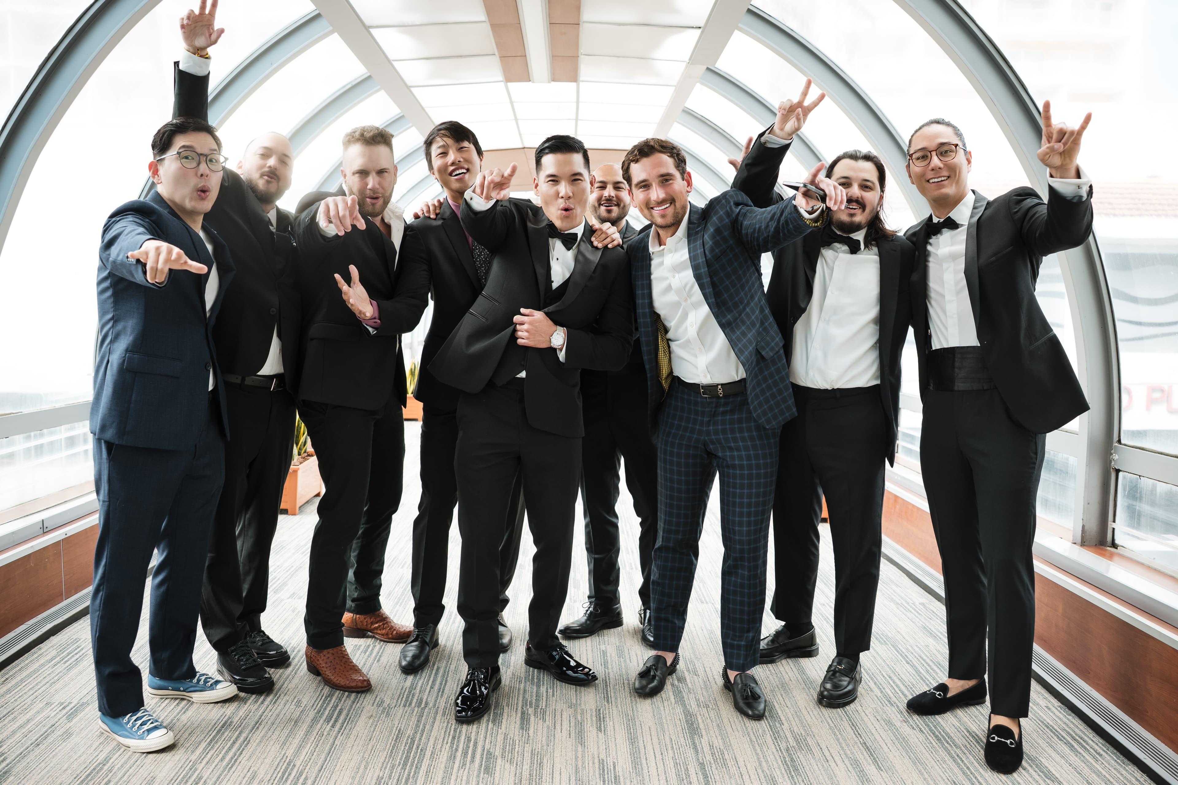 Groomsmen in black suits celebrating together on the wedding day